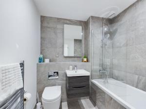 une salle de bain avec un lavabo, des toilettes et une baignoire dans l'établissement Stunning modern 1 bed apartment, à Belfast