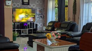 a living room with couches and a flat screen tv at 3 Bedroom Appartment with Beautiful view of Kilimanjaro Mountain in Moshi