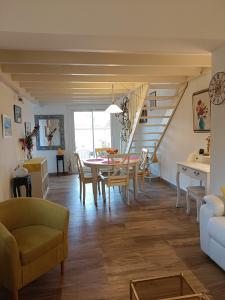 ein Esszimmer und ein Wohnzimmer mit Tisch und Stühlen in der Unterkunft VILLA CITRONNELLE Grande maison 2 chambres avec jardin proche plage - Clim - Wifi in Saint Cyprien Plage