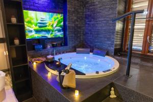 a bathroom with a jacuzzi tub with a tv at Lungomare Suite & Spa in Naples