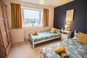 une chambre avec deux lits et une fenêtre dans l'établissement Seaview Beach house stones throws from the sea By Air Premier, à Seaford