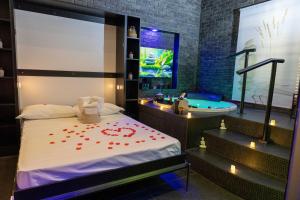 a bedroom with a tub and a bed with red flowers on it at Lungomare Suite & Spa in Naples