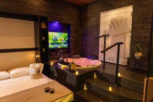 a bedroom with a tub and a tv in a room at Lungomare Suite & Spa in Naples