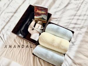 a box of towels and a book on a bed at 江元浅草 in Tokyo +275 photos
