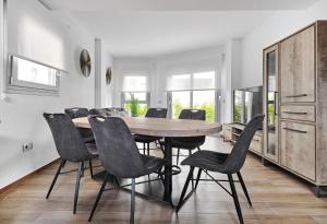 una sala da pranzo con tavolo e sedie in legno di Villa Amalia II - Heated Pool, Sauna & Jacuzzi a Torrevieja
