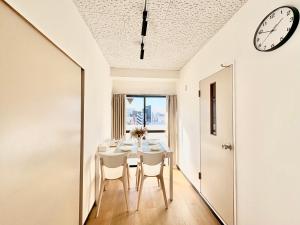 a dining room with a table and a clock on the ceiling at 江元浅草 in Tokyo