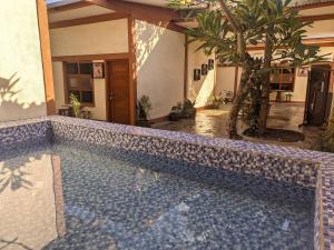 a tile swimming pool in a house with a palm tree at de Senthongs in Adi Sutjipto