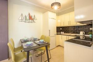 a kitchen with a table and chairs in a kitchen at Icon Deluxe accommodation in Pefkochori
