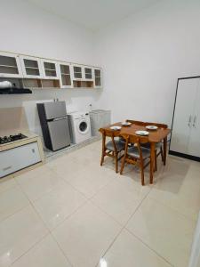 a kitchen with a table and a microwave at Villa Aisyahh in Sengkaling