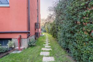 a stone path between a building and a wall at Charming apt in Villa with jacuzzi in Milan in Segrate