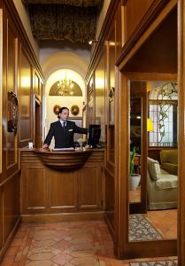 a man in a suit standing at a counter in a room at Hotel Pantheon in Rome