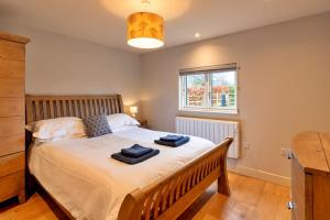 ein Schlafzimmer mit einem Bett mit zwei Handtüchern darauf in der Unterkunft Finest Retreats - Oak Cottage in Bidford