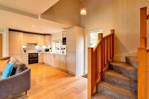 a living room with a staircase and a kitchen at Finest Retreats - Oak Cottage in Bidford