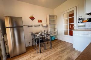 une cuisine avec une table avec des chaises et un réfrigérateur dans l'établissement Carla - vue mer clim wifi parking - by TGB, à Ajaccio 10 autres photos