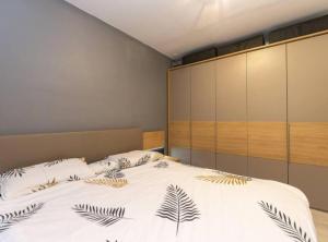 a bedroom with a large white bed with leaves on it at Zrmanja Canyon Apartment in Obrovac