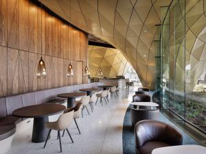a row of tables and chairs in a restaurant at Pullman Auckland Airport in Auckland