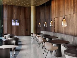a row of tables and chairs in a restaurant at Pullman Auckland Airport in Auckland