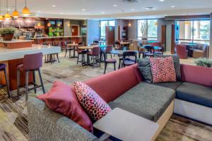 a living room with a couch and a restaurant at Courtyard Mobile Spanish Fort/Eastern Shore in Spanish Fort