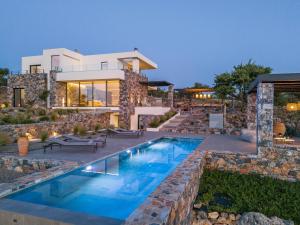 a house with a swimming pool in front of it at Villa Zenora in Litsárdha