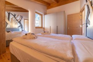 卡纳莱达戈尔多The Dreaming Home Dolomiti的房间里的一排床 更多102张照片