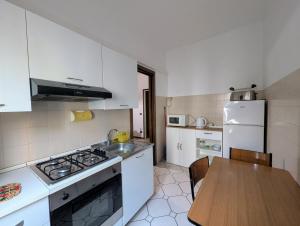 a kitchen with white appliances and a wooden table at Residenza Parco Ducale in Parma