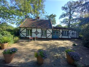 a white and black house with a patio at Ferienhaus Oppeln 21 in Wingst