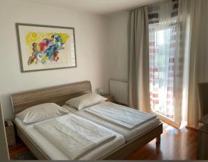 a bed in a bedroom with a large window at Pension Fürstenhof in Villach