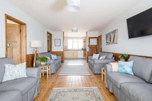 ein Wohnzimmer mit Sofas und einem Flachbildfernseher in der Unterkunft Bright & Dreamy On the Beach Garden & Balcony in Bracklesham Bay + 56 Fotos