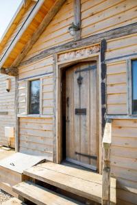eine Holztür an der Seite einer Hütte in der Unterkunft Bright & Dreamy On the Beach Garden & Balcony in Bracklesham Bay