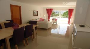 a living room with a couch and a table and chairs at Lovely Penthouse Apartment in Bellresguard in Port de Pollensa