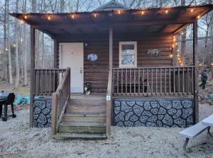 加特林堡Rustic Cabin in Smoky Mountain的小屋设有楼梯和带灯的门廊