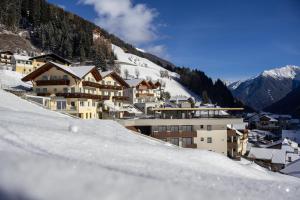 a group of buildings on a snow covered mountain at Apparthotel Sonnwies in Selva dei Molini