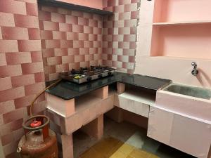 a small kitchen with a stove and a sink at Villa De Pondicherry in Pondicherry