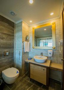 een badkamer met een wastafel, een toilet en een spiegel bij Dream World Aqua in Side
