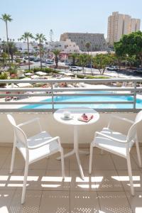 a patio with a table and two chairs and a pool at Olé Tropical Tenerife Adults Only in Playa de las Americas