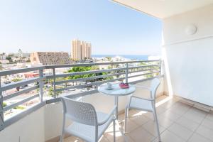 a balcony with a table and chairs and a view at Olé Tropical Tenerife Adults Only in Playa de las Americas