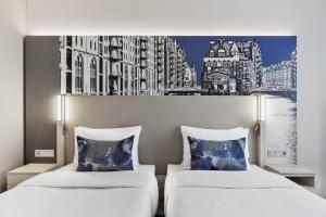 two beds in a room with a painting on the wall at Courtyard by Marriott Hamburg City in Hamburg