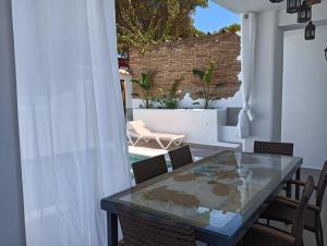 un tavolo in vetro e sedie su un patio di Nueva Casa Alhamar a Punta Umbría
