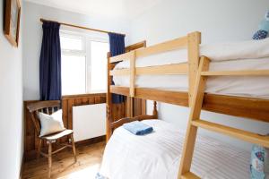 1 Schlafzimmer mit 2 Etagenbetten und einem Stuhl in der Unterkunft Bright & Dreamy On the Beach Garden & Balcony in Bracklesham Bay