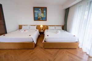 Postel nebo postele na pokoji v ubytování Palm Riverside Boutique