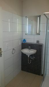 ein Bad mit einem Waschbecken und einem Spiegel in der Unterkunft Nordseeperle in Hage