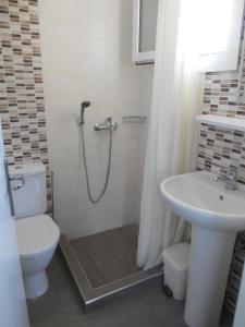 ein Bad mit einer Dusche, einem WC und einem Waschbecken in der Unterkunft Apartments Seagull in Kos-Stadt