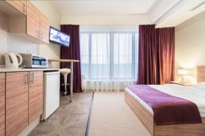 a hotel room with a bed and a microwave at Hills Hotel апарт-отель in Moscow
