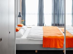 a bedroom with a bed with an orange and white blanket at MLOFT Apartments München in Munich +22 photos