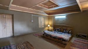 a bedroom with a bed and a coffered ceiling at MudHouse Retreat, Sarajara in Bīr