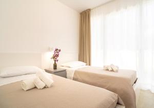 pokój hotelowy z 2 łóżkami i ręcznikami w obiekcie Baia Marzamemi appartamenti Vendicari, Balata, Tonnara, Cortile del Rais w mieście Marzamemi +37 zdjęć