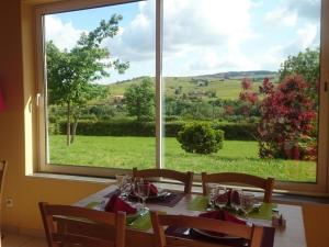 a dining room table with a view of a window at La Ferme Du Chapi in Saint-Laurent-dʼOingt +4 photos