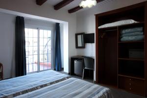 a bedroom with a bed and a window and a desk at Hotel Marblau Tossa in Tossa de Mar
