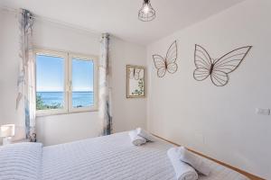 a bedroom with a bed with butterflies on the wall at Casa Mulas in Tertenìa