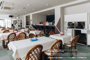 关市湯沢雪の宿 YUZAWA Snow Inn-Ski IN Ski OUT的一间带白色桌椅的餐厅和一间厨房